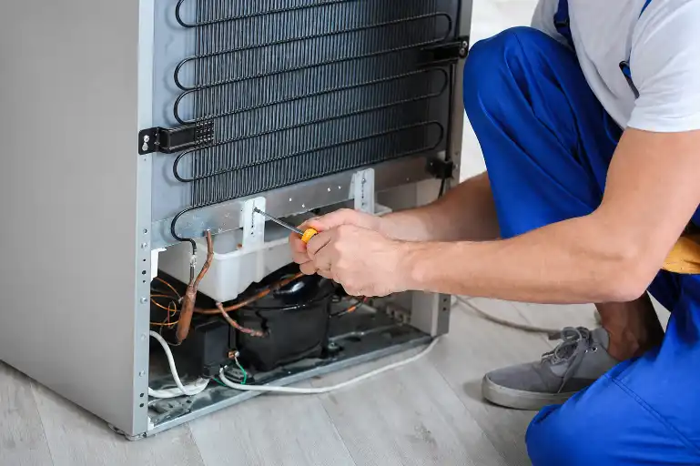 Technician repairing internal compressor and cooling parts of a refrigerator